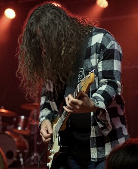 Brian in a plaid shirt under red light